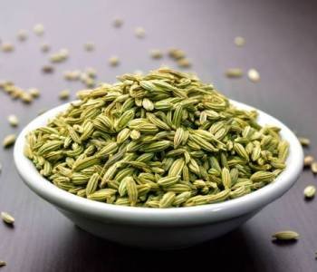 Fennel seeds in a bowl on a wooden table