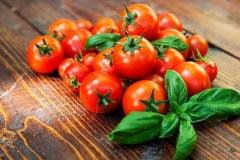 Cherry tomatoes and basil on wooden background